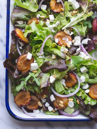 Mixed Greens with Roasted Italian Plums - these roasted plums add the most delicious flavor to this early fall salad topped with bits of creamy goat cheese and toasted buttery pine nuts. | @tasteLUVnourish on TasteLoveAndNourish.com