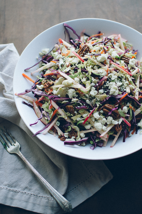 This crunchy Red Cabbage and Brussels Sprouts Slaw is my family's favorite salad! It's absolutely loaded with pecans, sunflower seeds, sweet apple slices and crumbles of blue cheese and topped with a Dijon Maple Vinaigrette. | @tasteLUVnourish