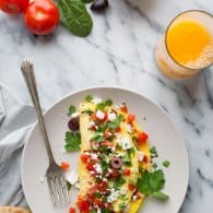 If you love bold Mediterranean flavors, the feta cheese, Kalamata olives, tomatoes and roasted red peppers in this simple and fluffy omelet are calling your name. | @tasteLUVnourish | Vegetarian | Gluten Free