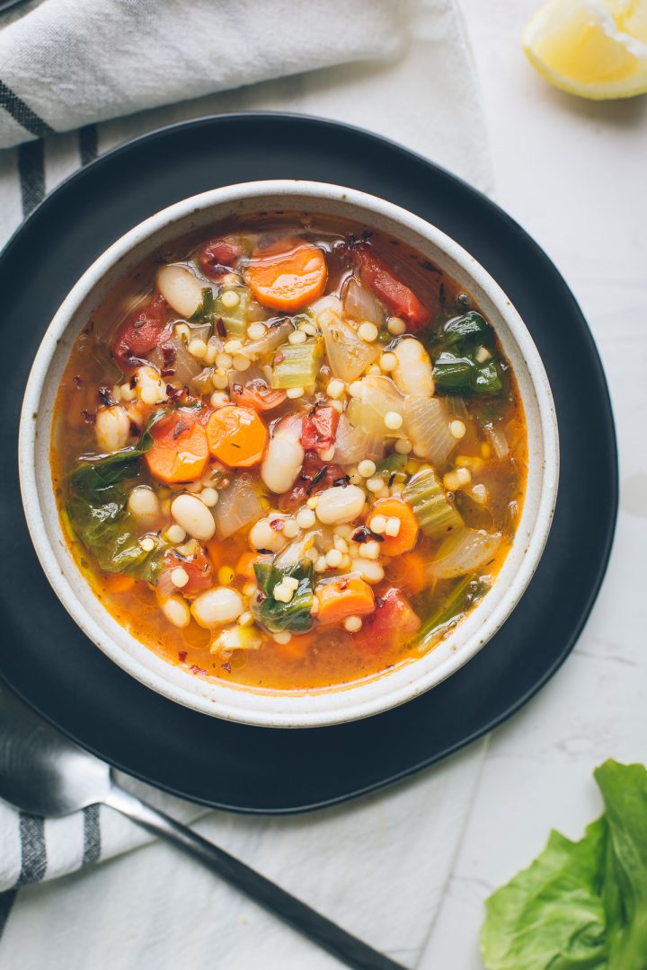 This simple, warming Escarole White Bean and Tomato Soup, full of complex flavors, is so nourishing and easily adapts to whatever you've got on hand. Make this your go-to winter soup. Naturally vegan with gluten-free options. From @tasteLUVnourish