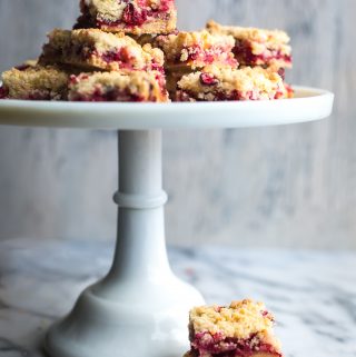 These Cranberry Bars are a simple, easy dessert that taste amazing! They've got a delicate, buttery, orange scented shortbread crust with a sweet, tangy cranberry filling. #tasteloveandnourish #cranberrybars #cookie #holiday #baking #recipe #easy #glutenfreeoptions